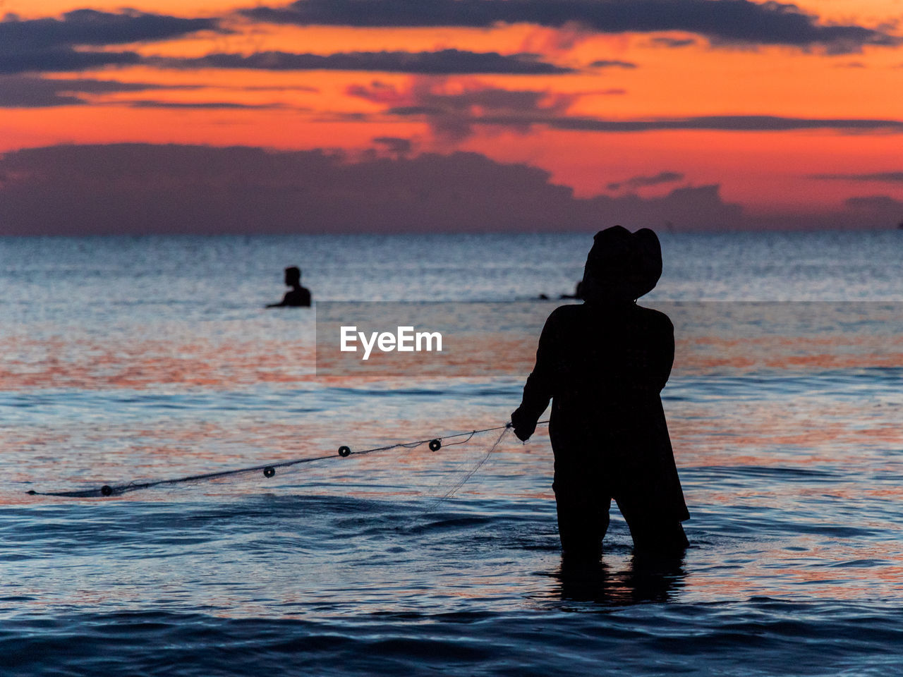 A fisherman is fishing at sunset on koh rong, cambodia