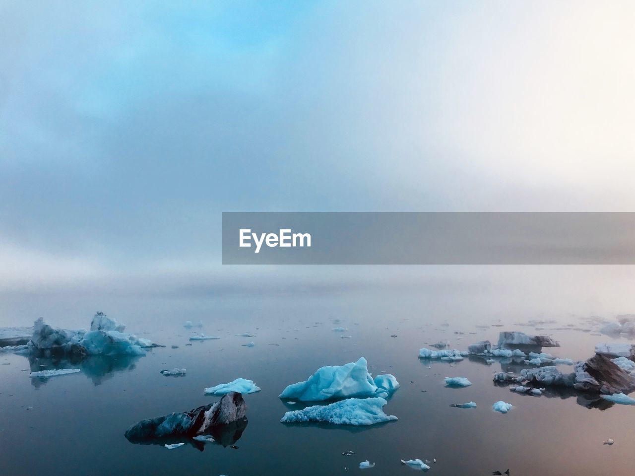 Scenic view of ice floating on sea against sky