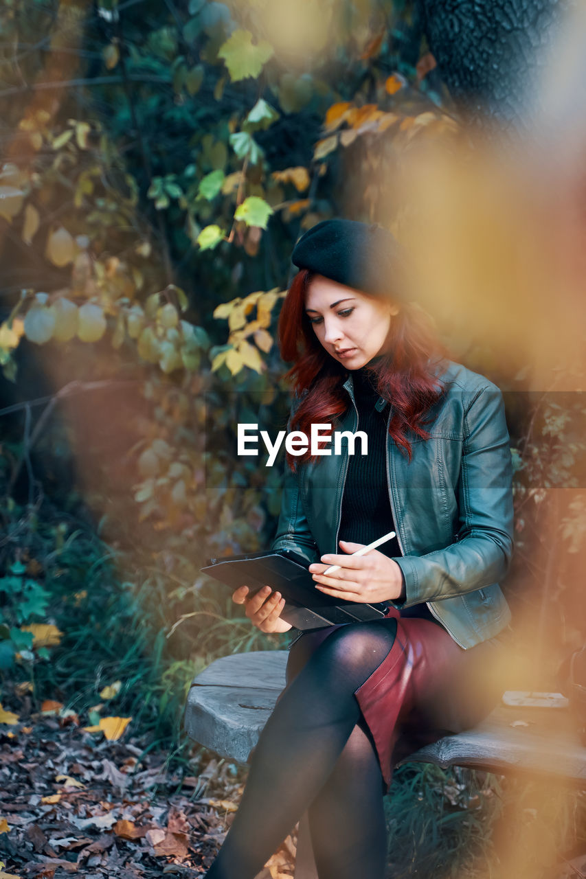 Young woman looking away while using mobile phone