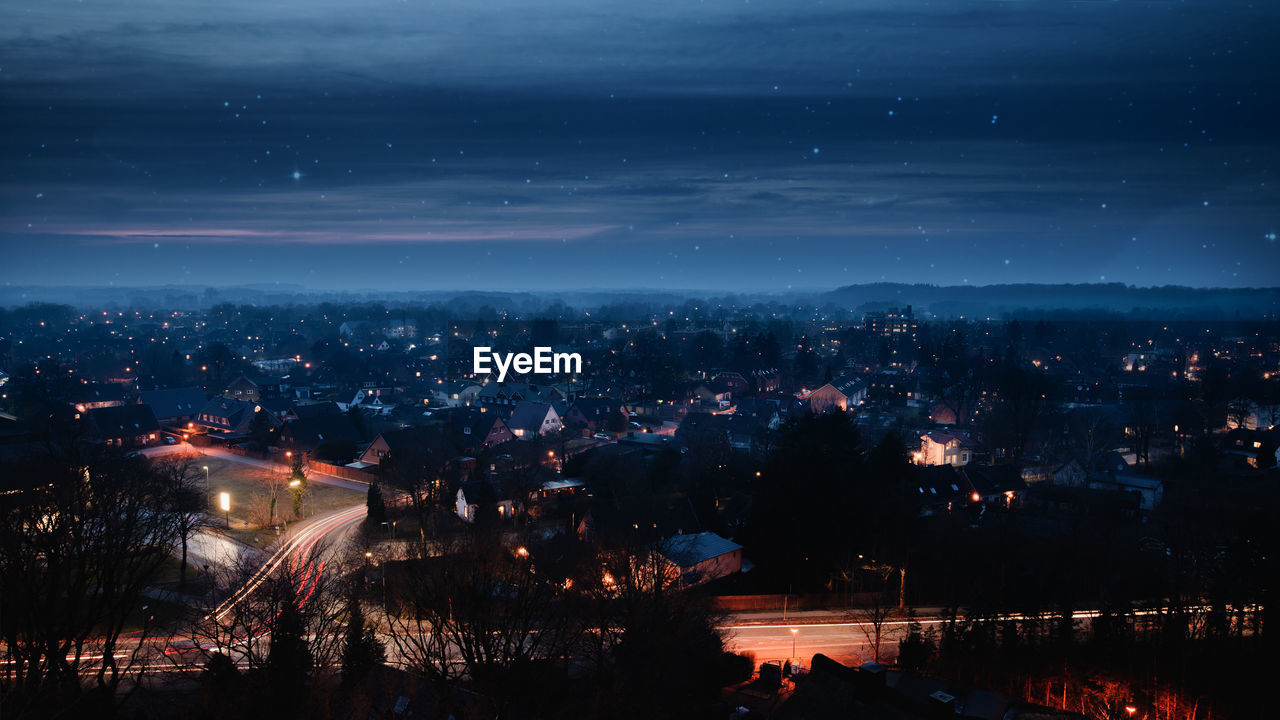 Illuminated cityscape against sky at night