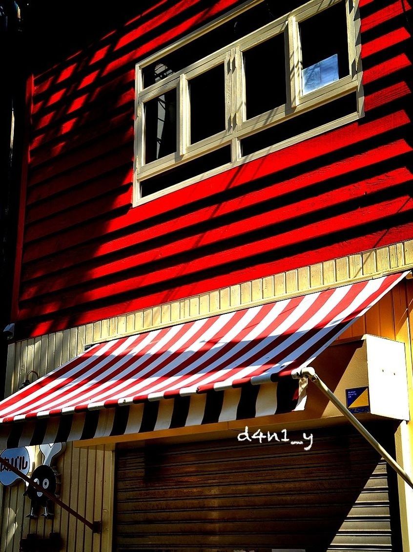LOW ANGLE VIEW OF ILLUMINATED TEXT ON RED BUILDING