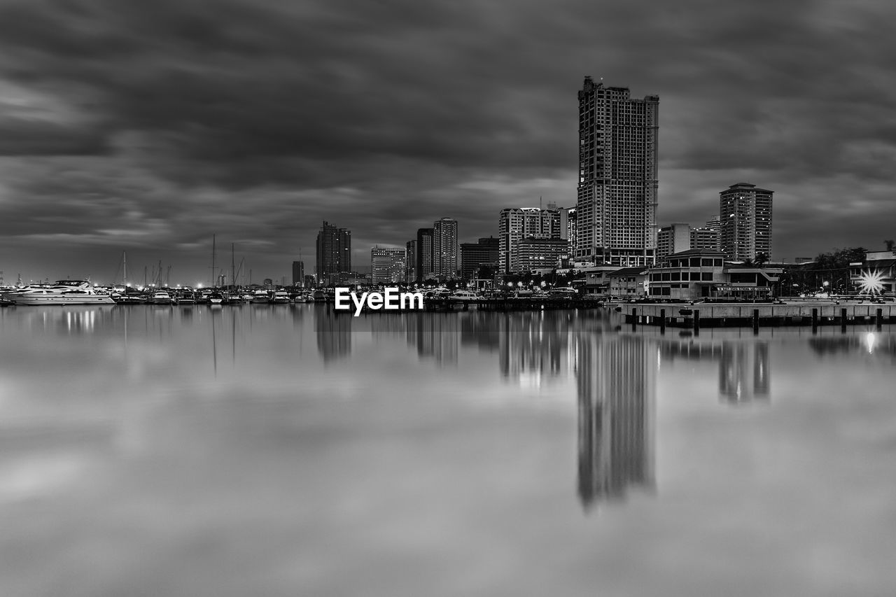 Scenic view of sea by city against cloudy sky