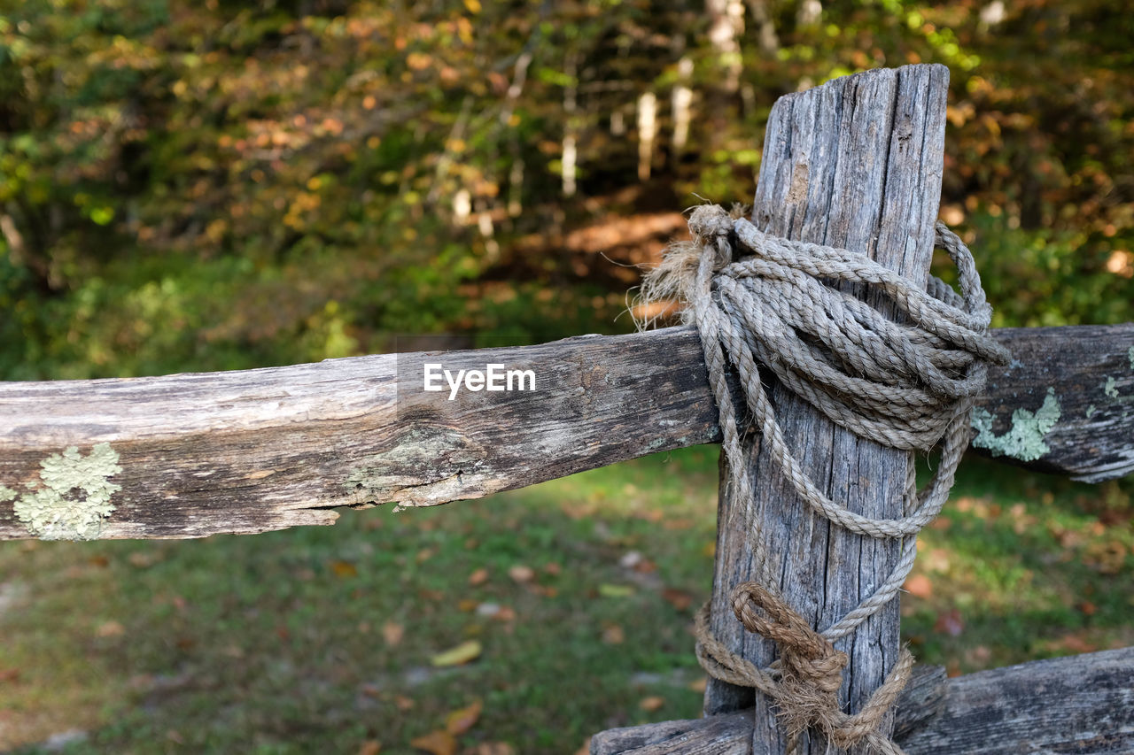 Rope on wooden fence at field