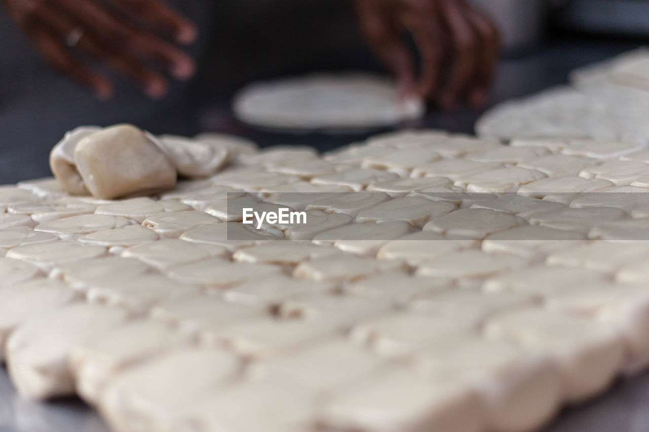 Close-up of halwa puri dough hand on cutting board