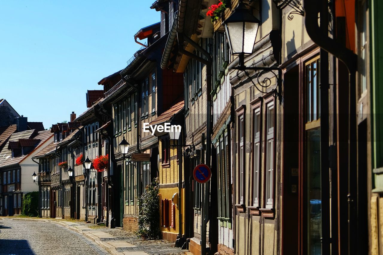 STREET AMIDST BUILDINGS AGAINST CLEAR SKY