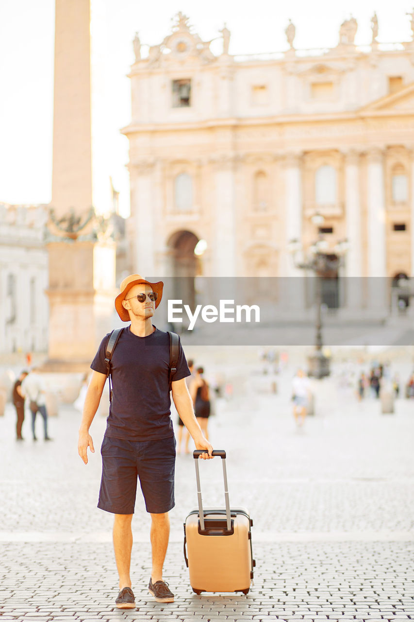 Young man tourist in rome at vatican city on vacation, an emigrant. moving to a new country.