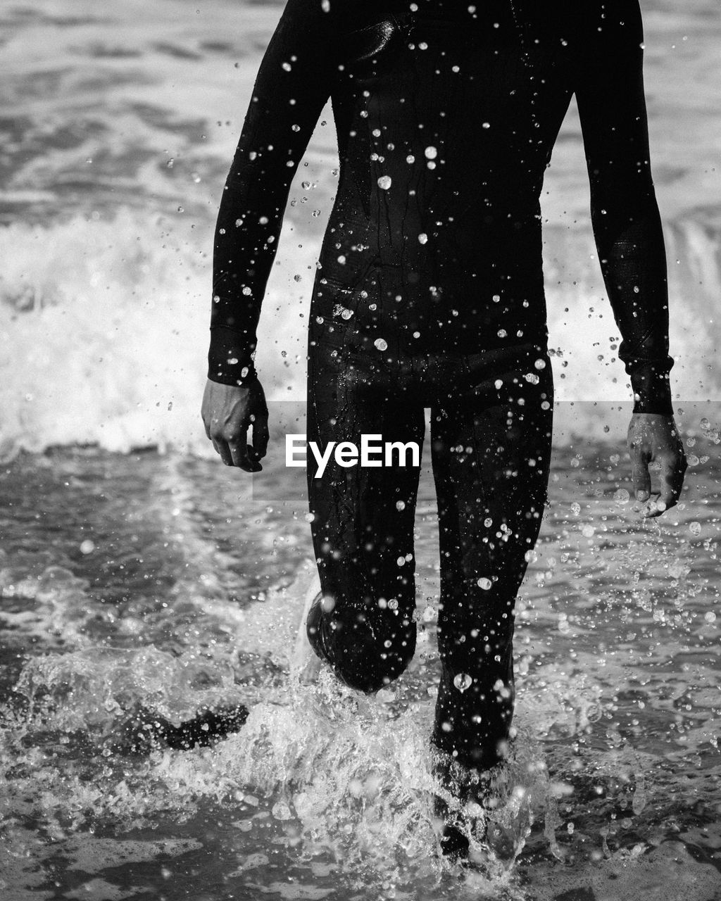 Man in wetsuit splashing water at the beach