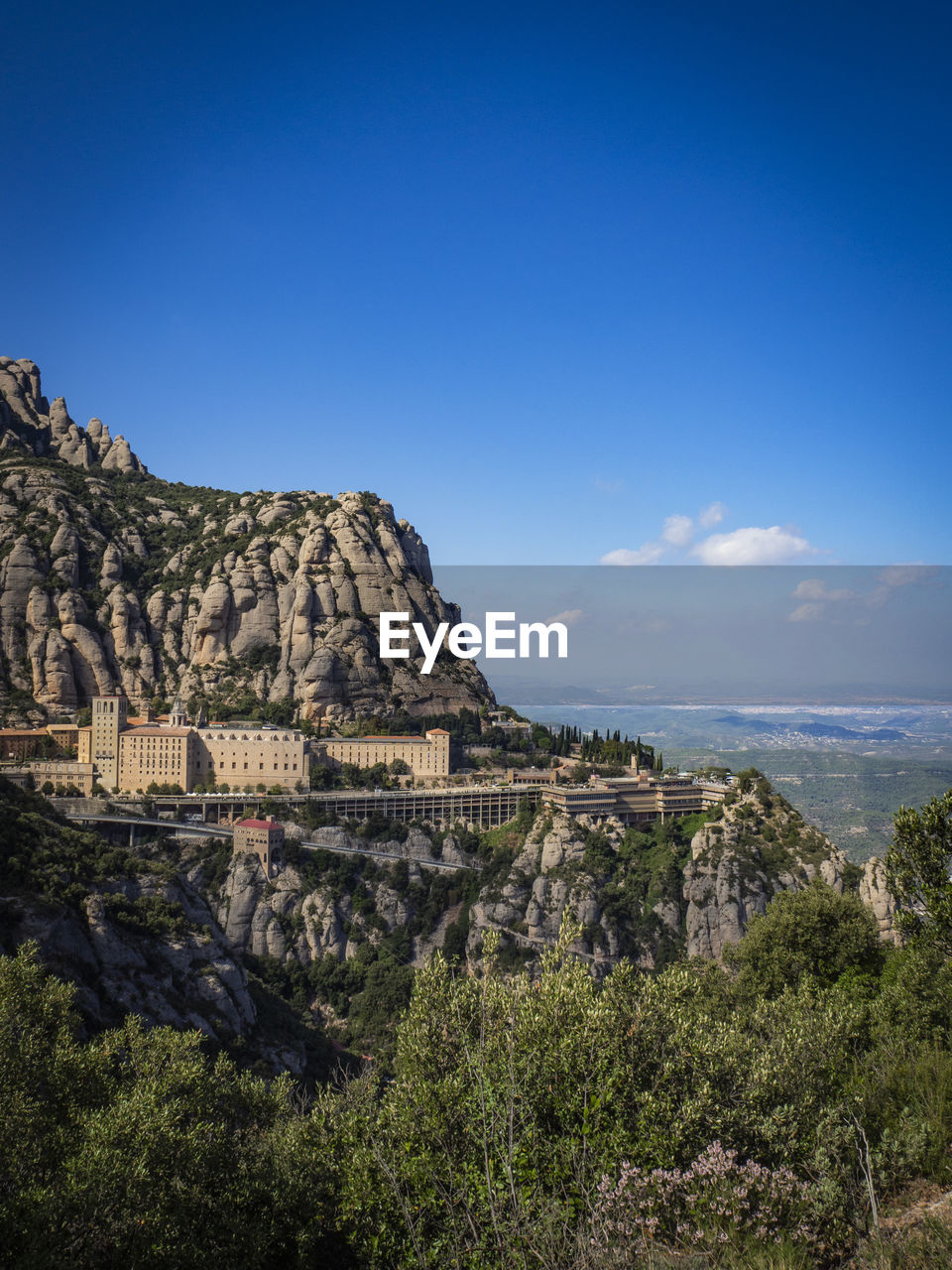 Scenic view of monastery and mountains against blue sky