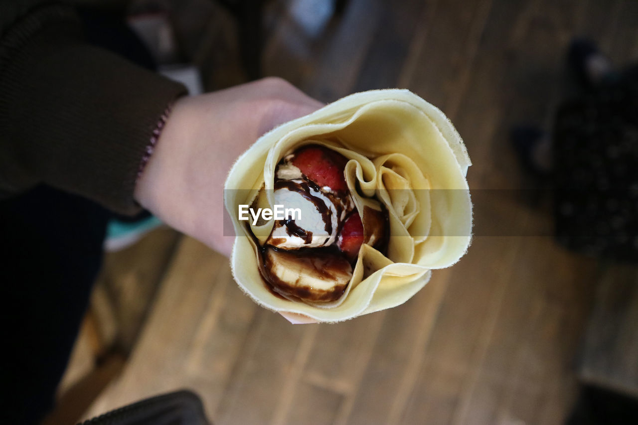 Cropped hand holding ice cream cone