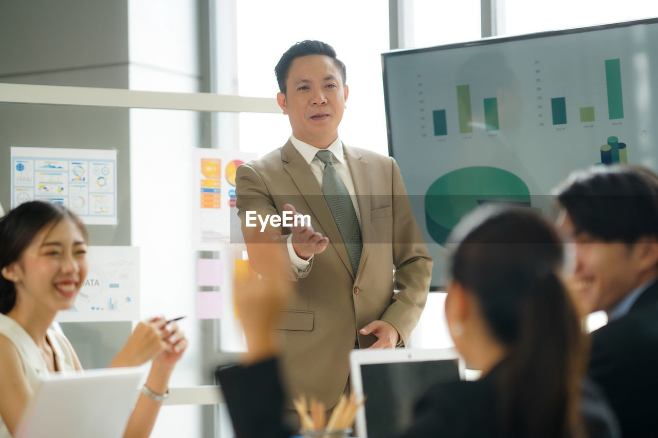 business colleagues shaking hands while standing in office