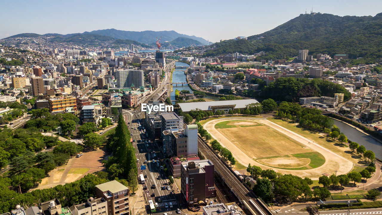 HIGH ANGLE VIEW OF TOWN AGAINST CLOUDY SKY