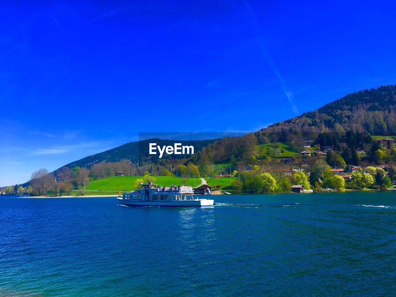 Scenic view of sea and mountains against blue sky