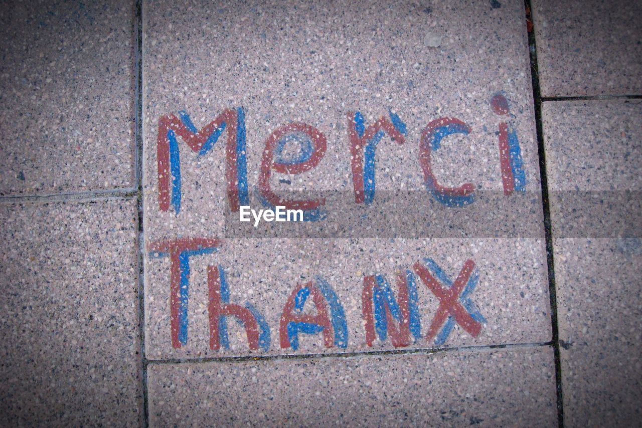 High angle view of thank you text on footpath