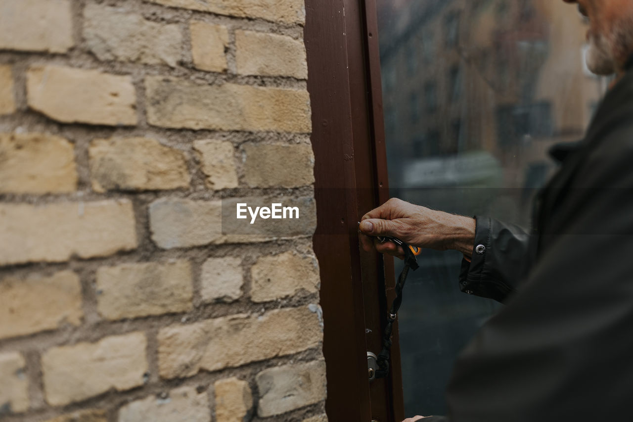 Midsection of salesman closing door of antique shop