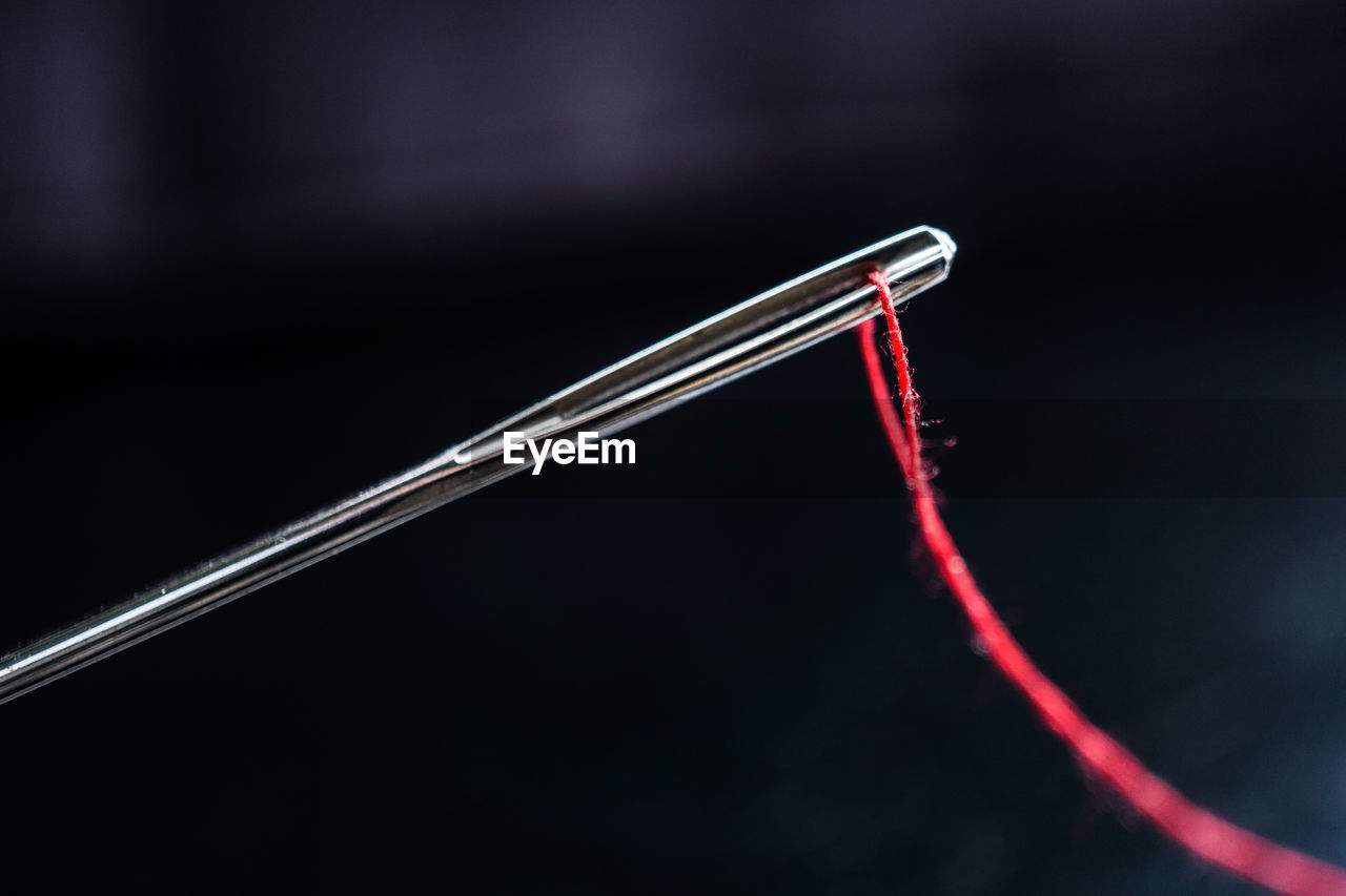 Close-up of red thread in sewing needle