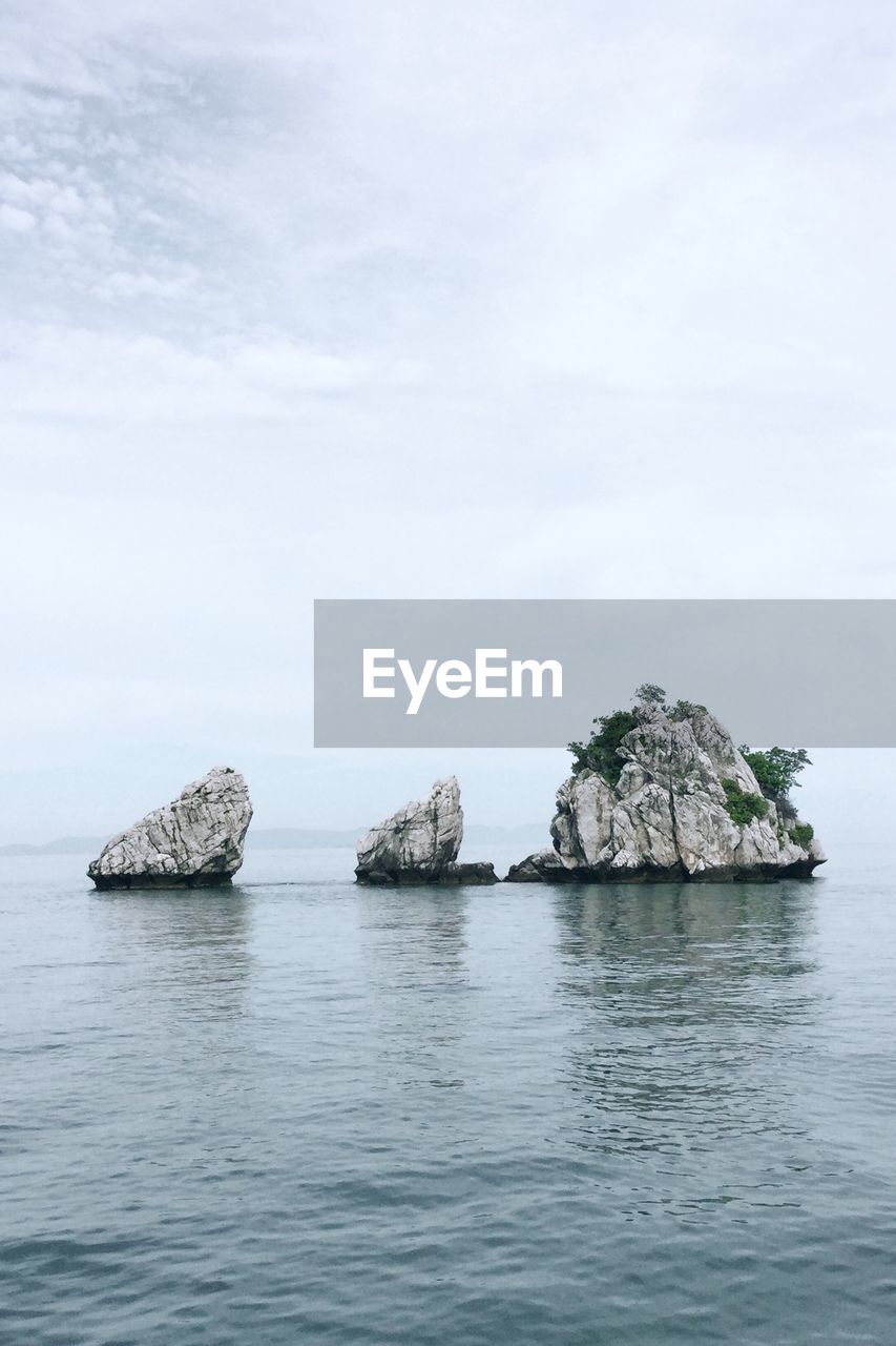 Rock formation in sea against sky