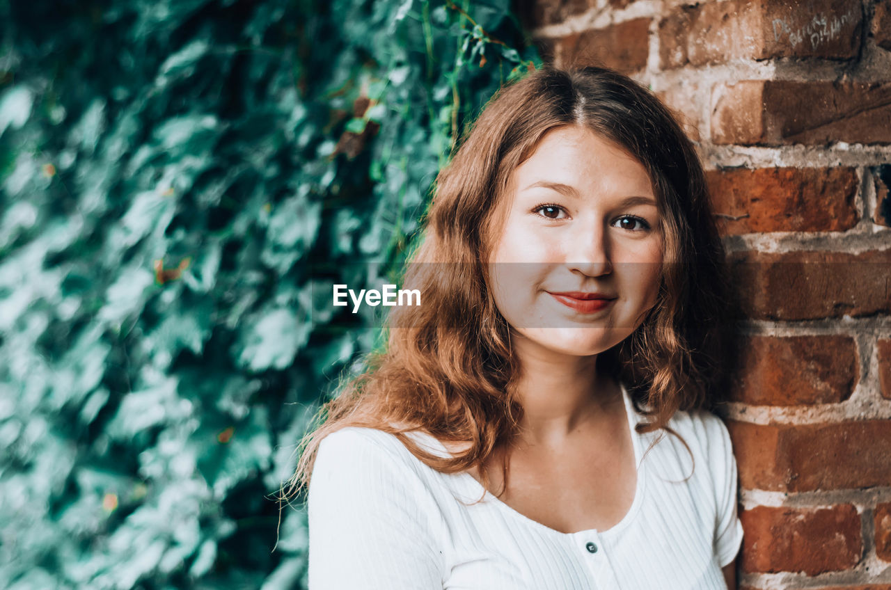 Portrait of smiling girl against wall