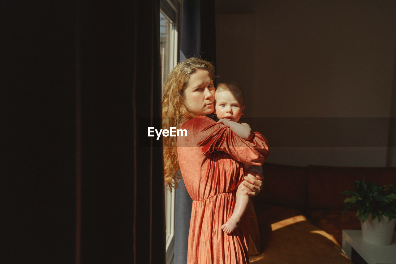 Mother and baby boy standing at home