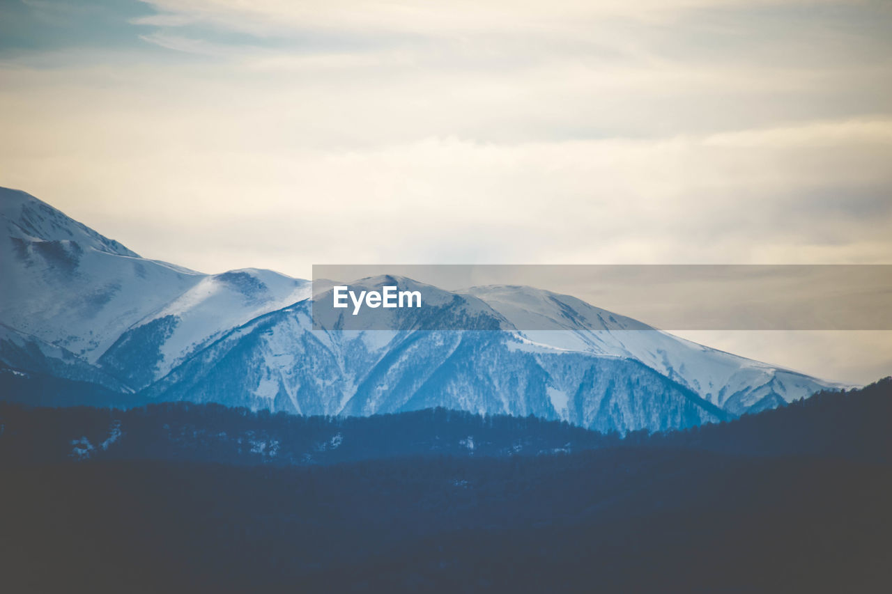 SCENIC VIEW OF SNOWCAPPED MOUNTAINS AGAINST SKY DURING WINTER