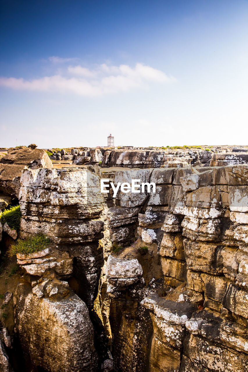 Scenic view of cliff against blue sky