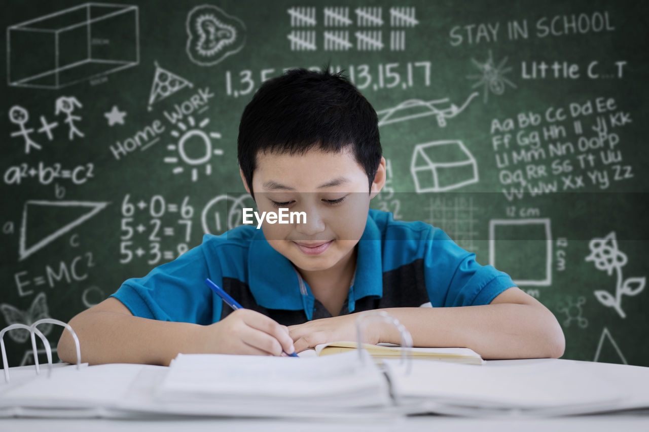 Worried boy studying at table