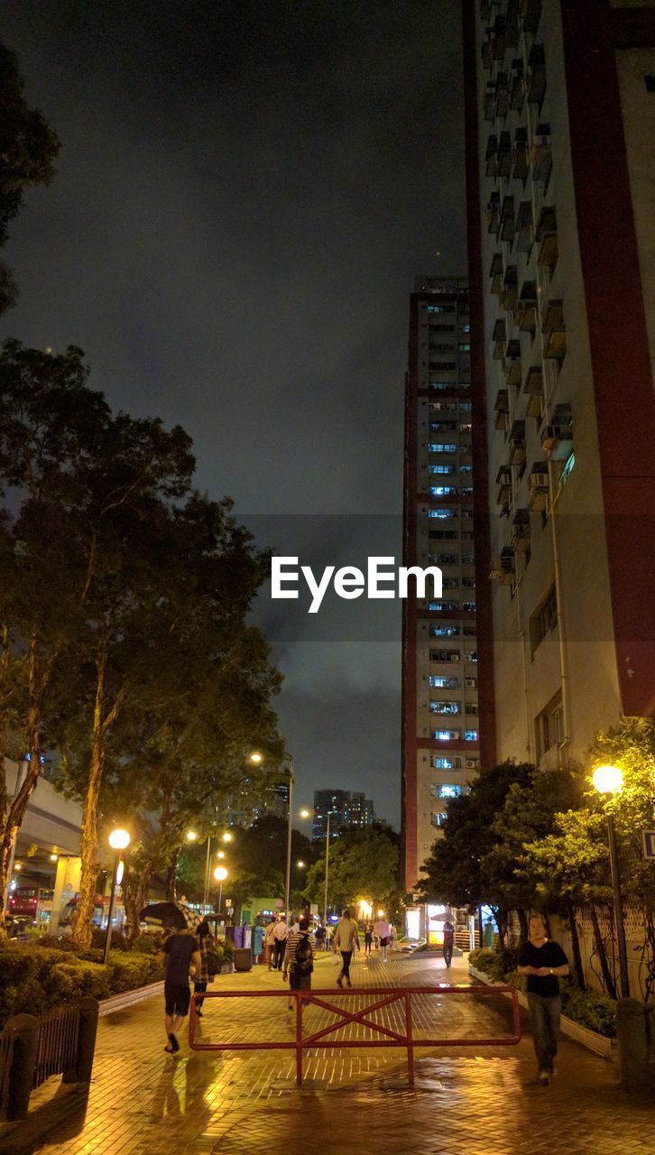 ILLUMINATED MODERN BUILDING AGAINST SKY AT NIGHT