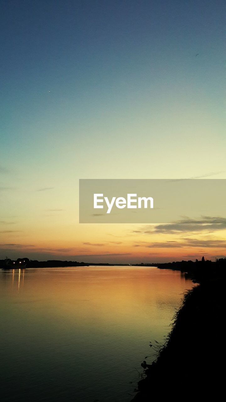 SCENIC VIEW OF LAKE AGAINST ROMANTIC SKY DURING SUNSET