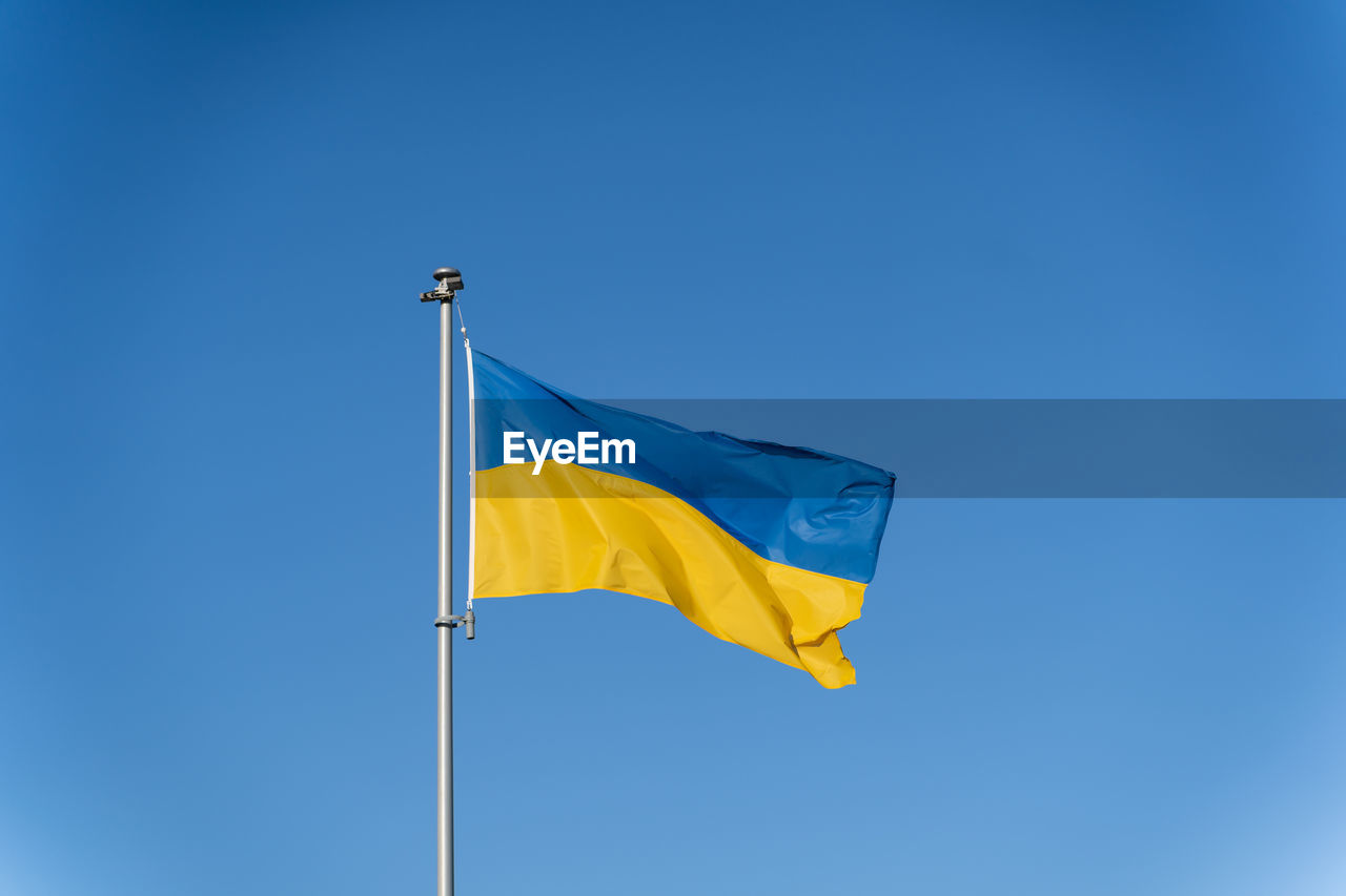 Ukrainian flag of yellow-blue colors on the background of clear blue sky