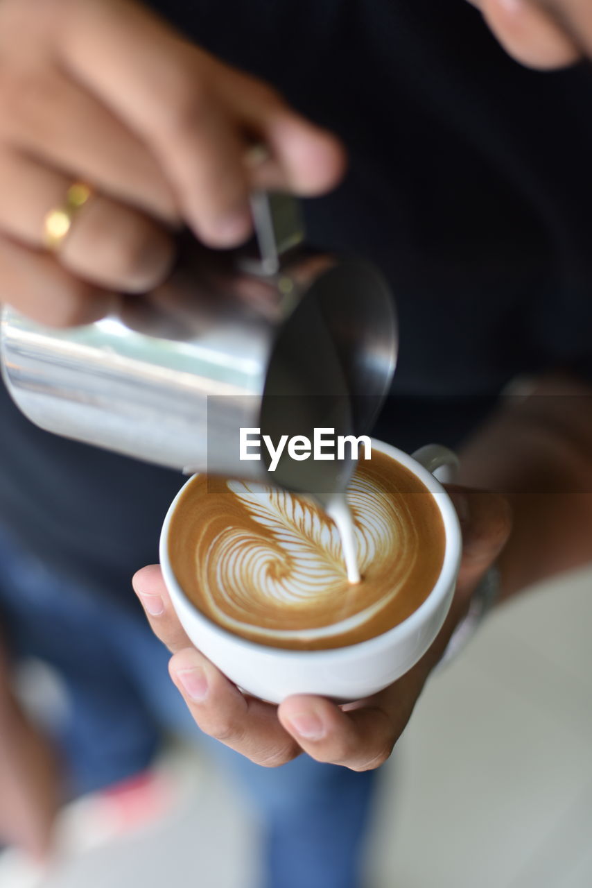 Close-up of hand holding coffee cup