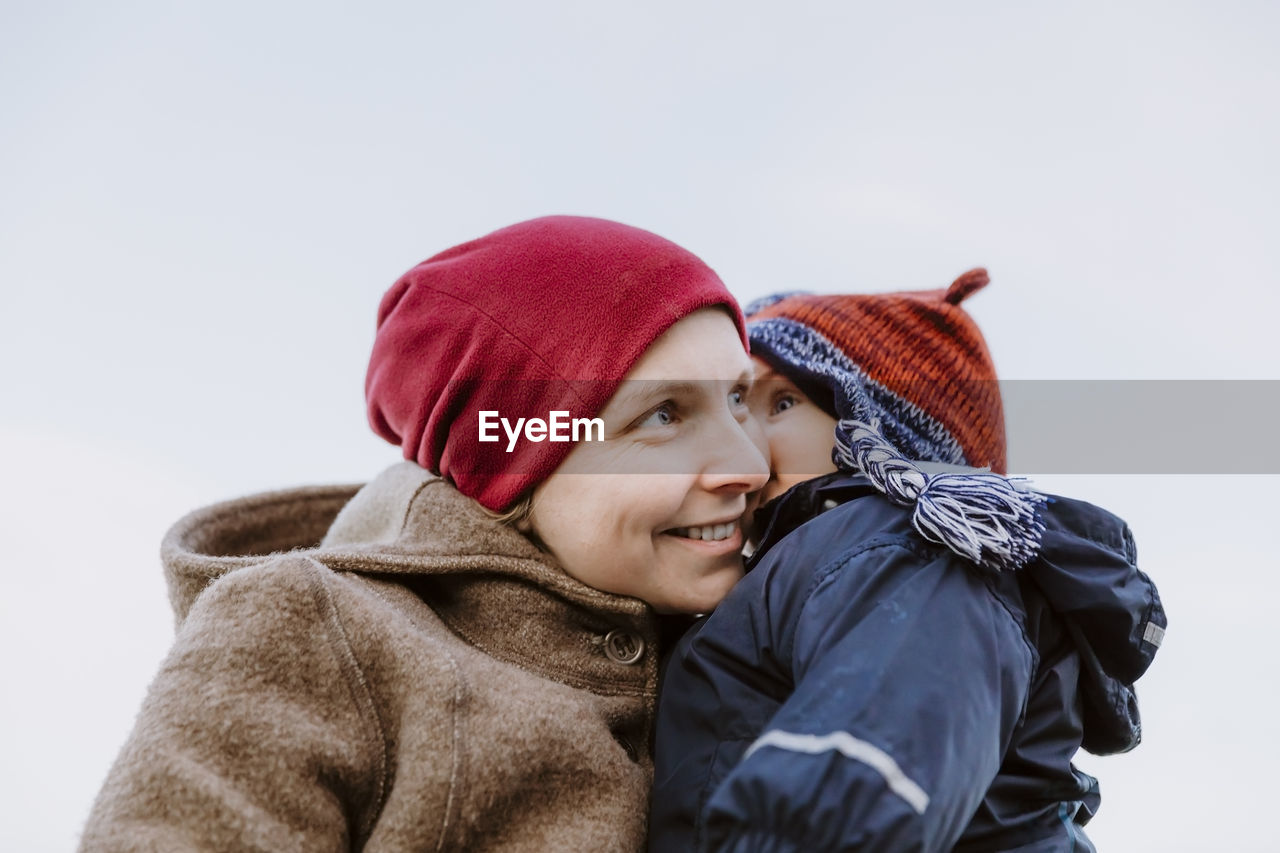 Close-up smiling woman with daughter during winter