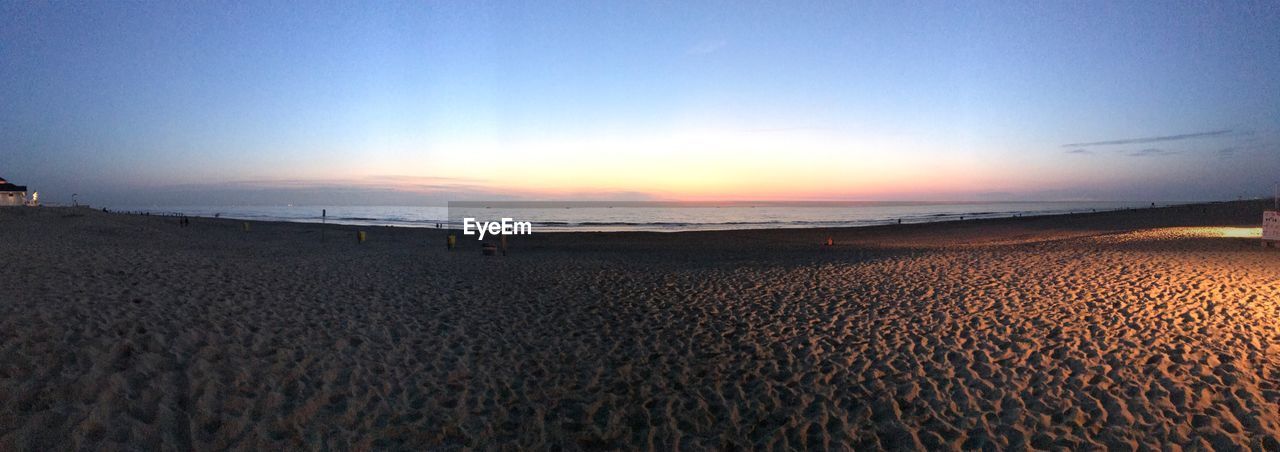 SCENIC VIEW OF BEACH AGAINST CLEAR SKY DURING SUNSET