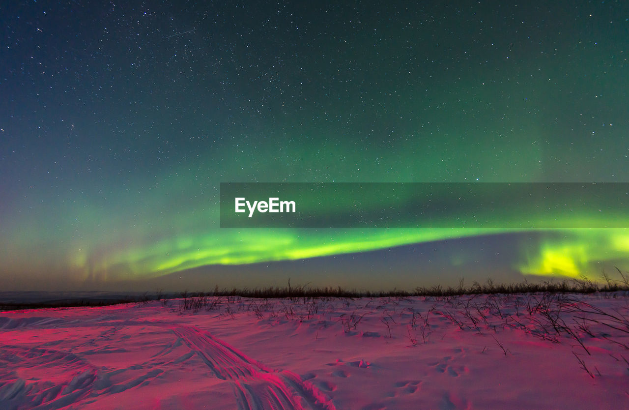 Scenic view of snowcapped field against sky at night