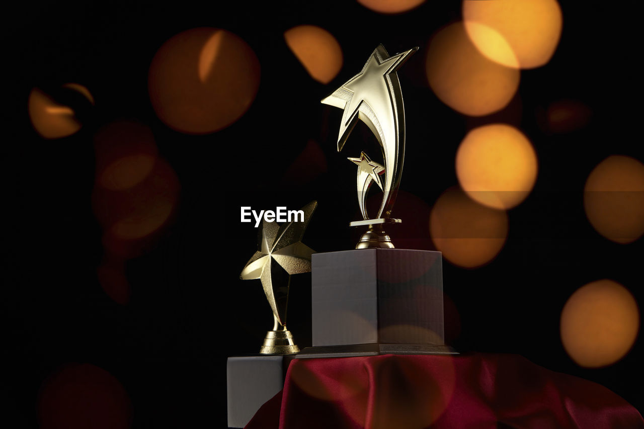 Close-up of awards on table against illuminated lights