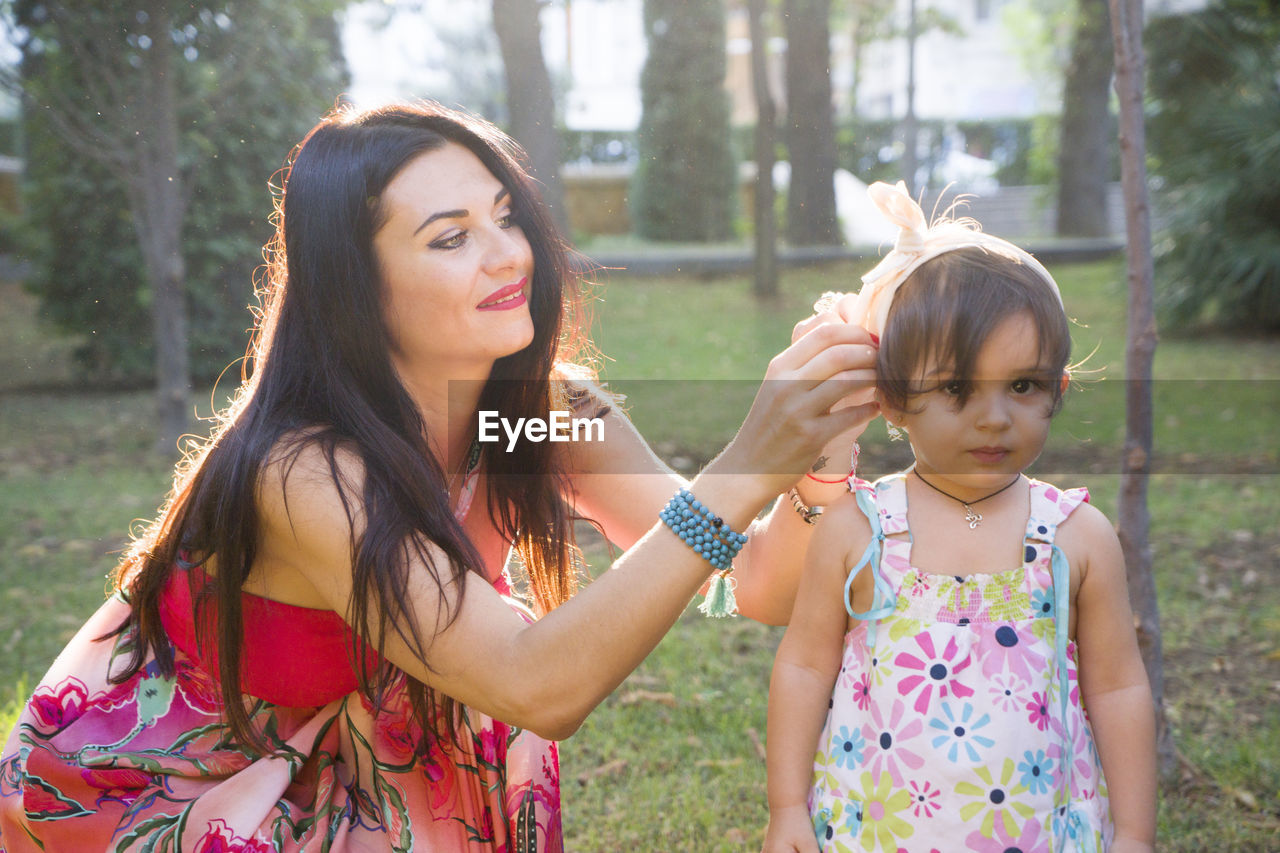 Happy mother and daughter in the park. beauty nature scene with family outdoor lifestyle. 