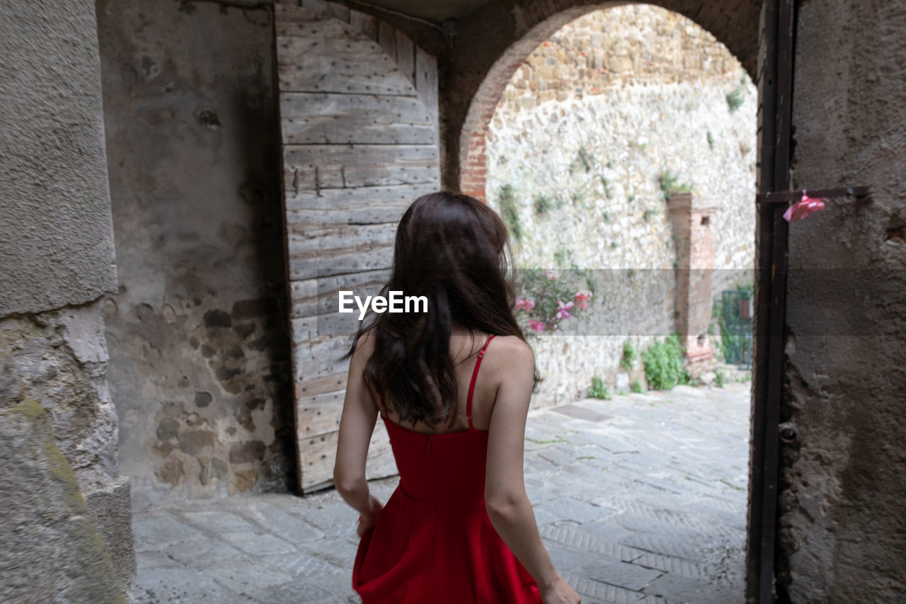 Rear view of woman standing against doorway