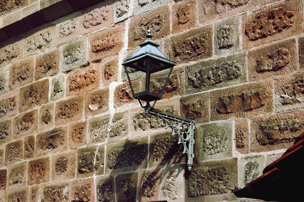 Low angle view of gas light on brick wall
