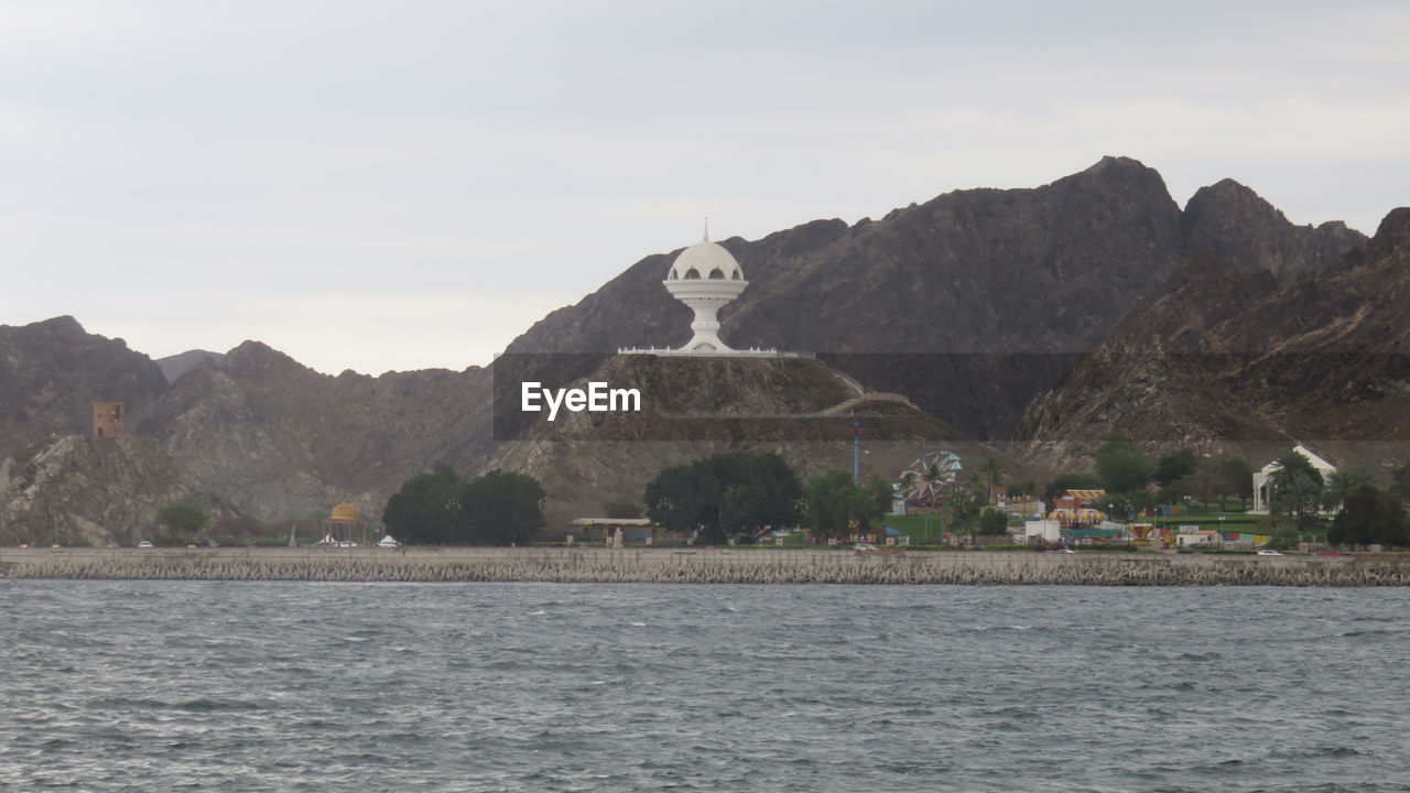 Scenic view of mutrah corniche by lake against sky