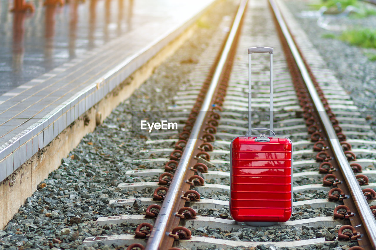 Close-up of wheeled luggage on railroad tracks