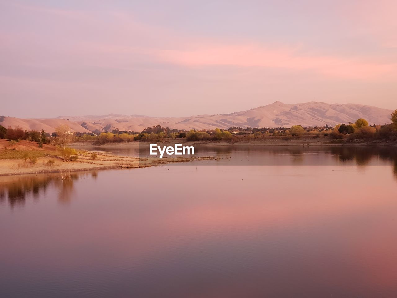 Scenic view of lake against sky during sunset