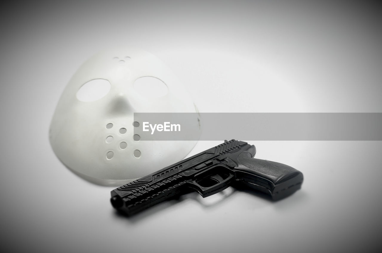 Gun and mask face on low light