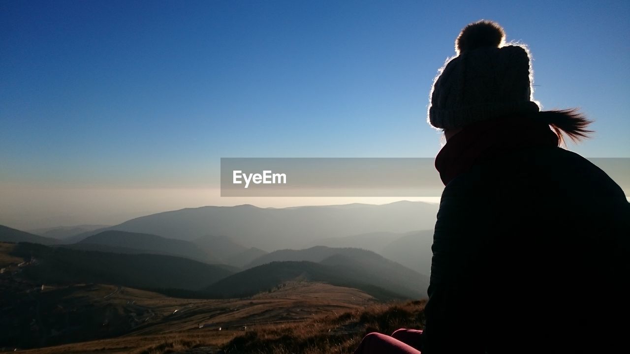 Close-up of silhouette woman on mountain against sky