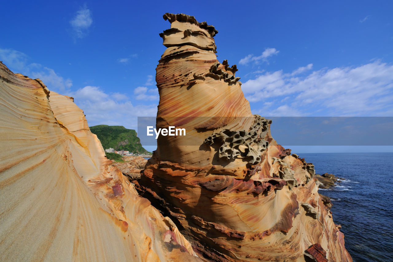 Rock formations by sea against sky