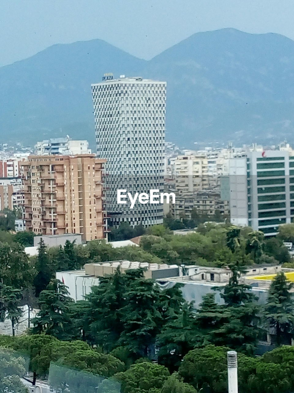 HIGH ANGLE VIEW OF BUILDINGS AND SEA AGAINST SKY