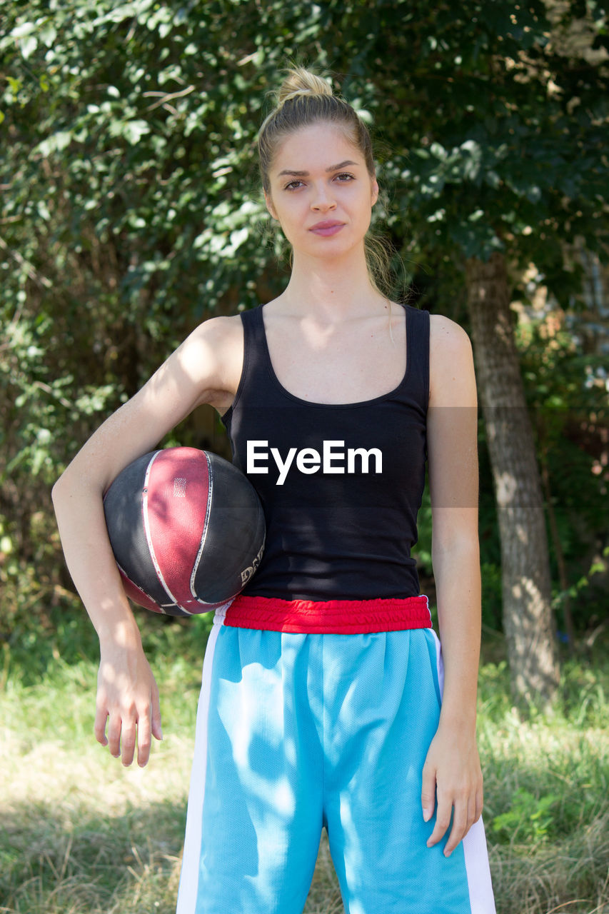 Portrait of smiling player holding basketball