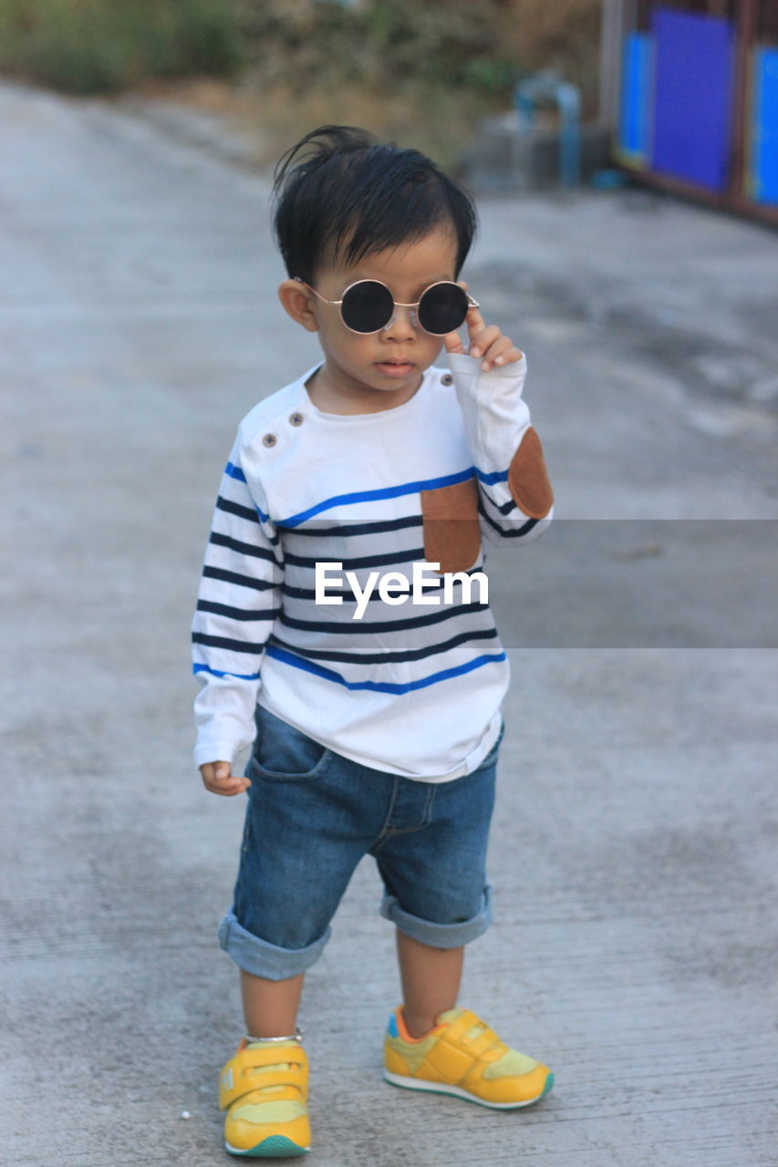 Asian boys wearing black fashion glasses and white striped shirts.