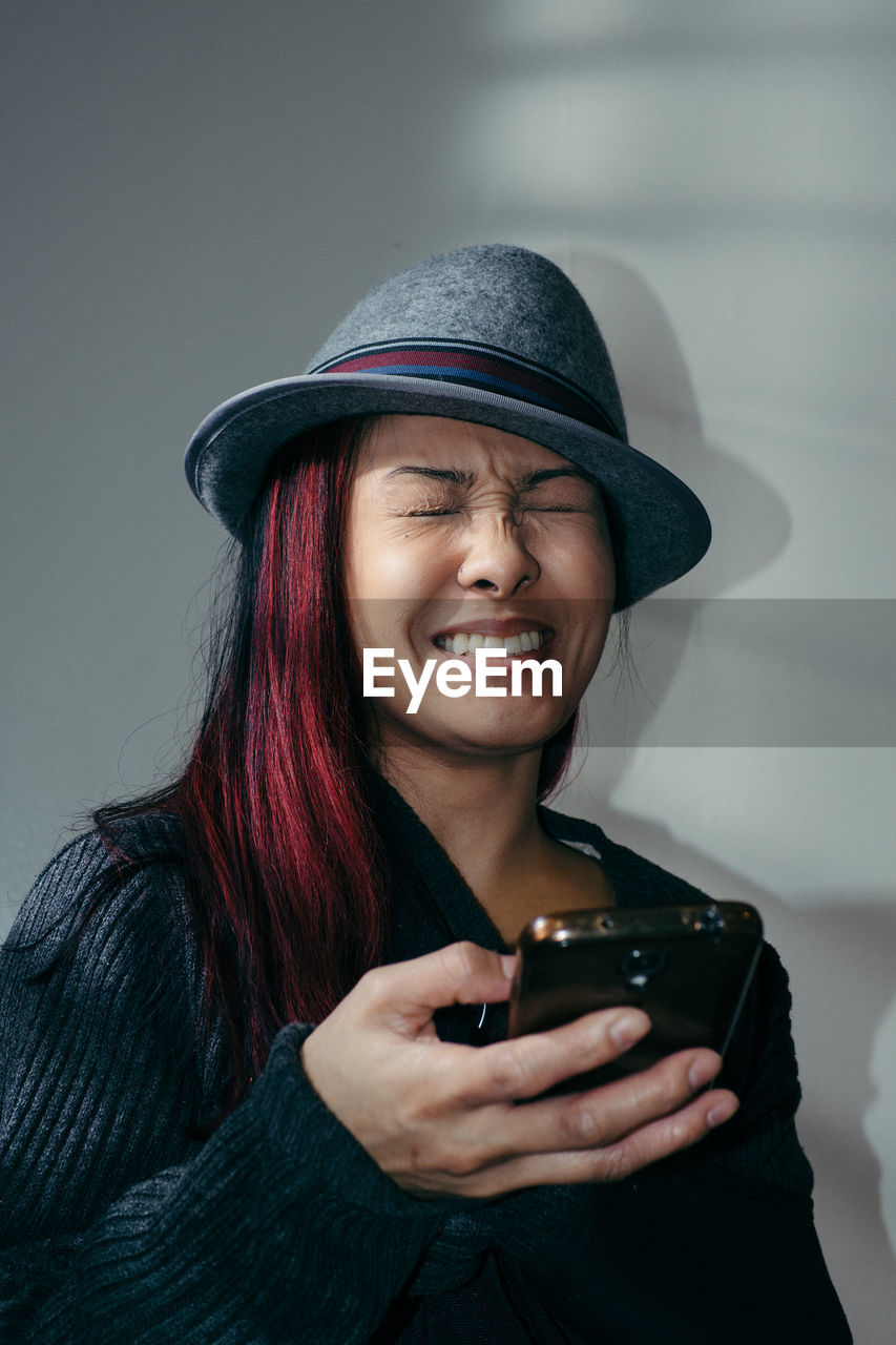 PORTRAIT OF SMILING YOUNG WOMAN USING LAPTOP