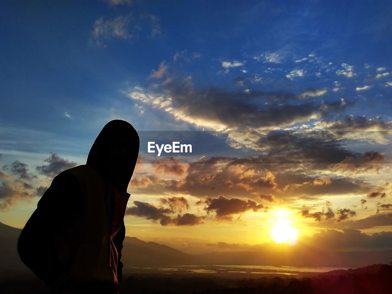 SILHOUETTE MAN AGAINST CLOUDY SKY DURING SUNSET