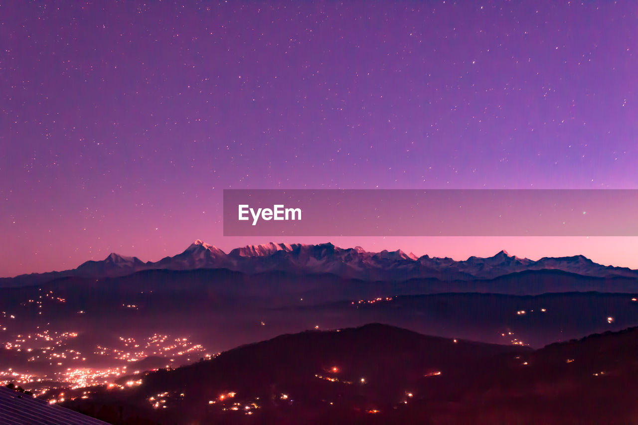 Silhouette mountains against sky at night