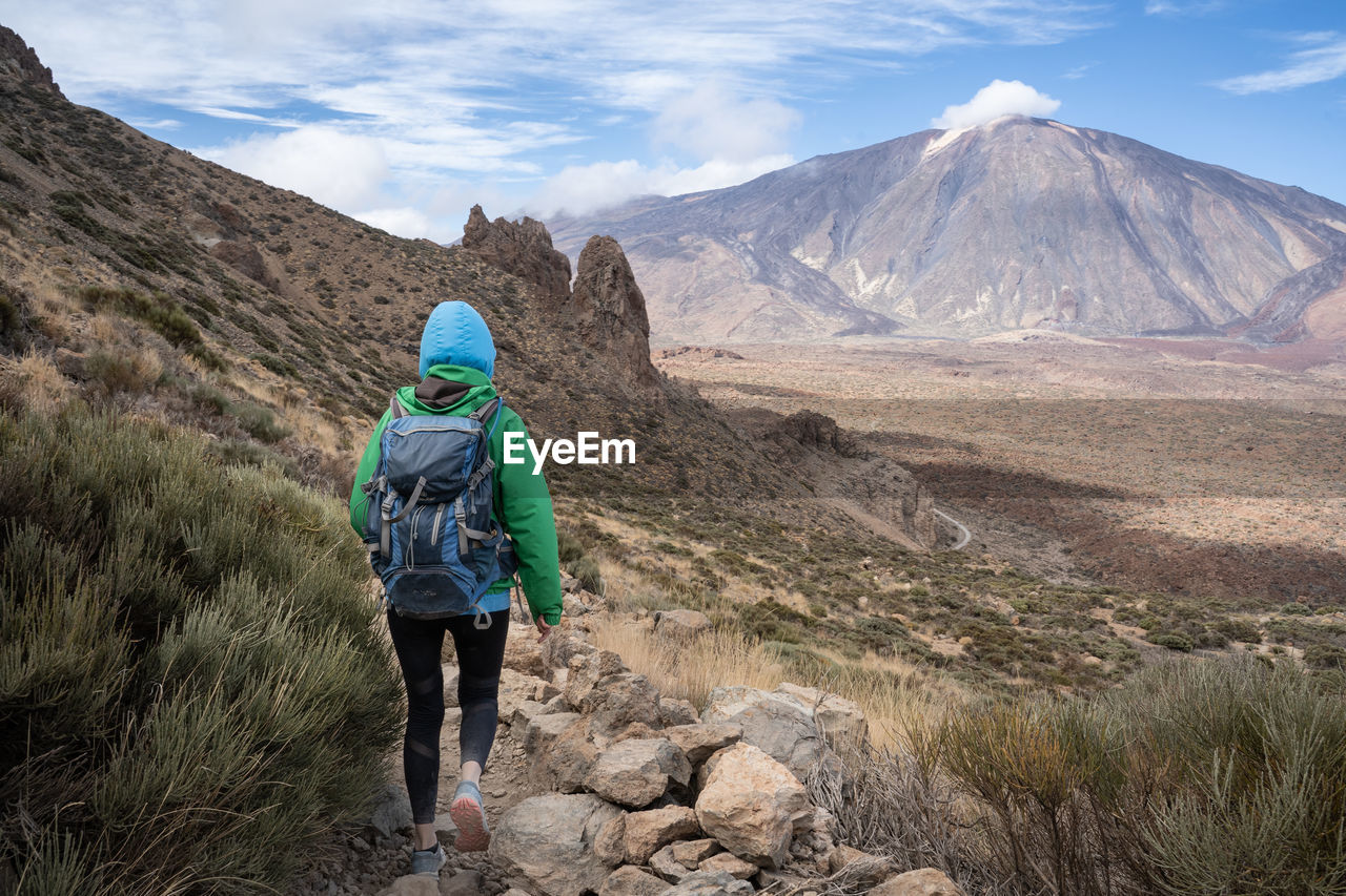 Woman hiking on trail with a view on teide mountain
