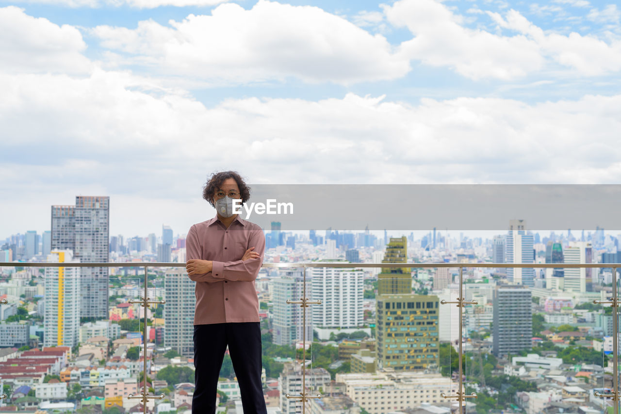 FULL LENGTH OF MAN STANDING ON CITY AGAINST BUILDINGS